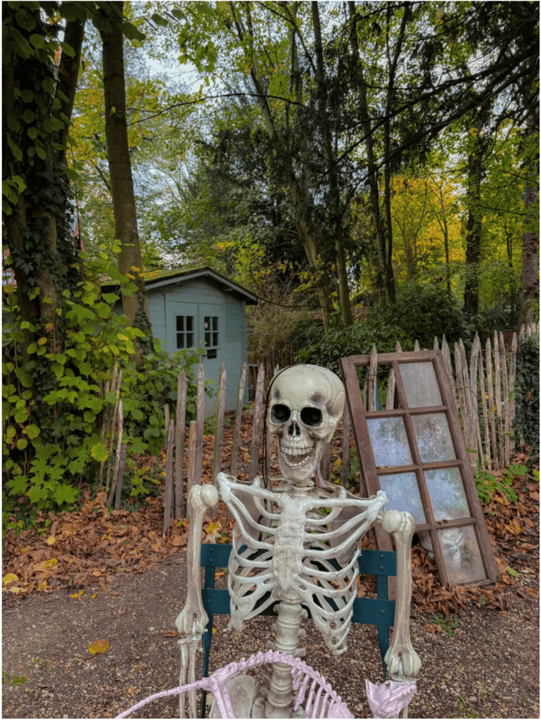 Squelette installé sur un banc dans les jardins du Potager des Princes à Chantilly, au milieu des décorations d'Halloween.