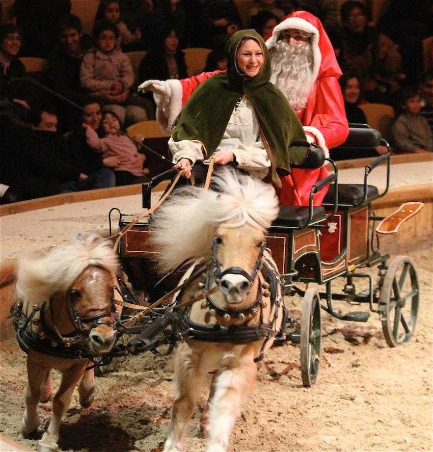 Le Père Noël à bord d'une calèche tirée par deux poneys lors d'un ancien spectacle équestre de Noël aux Grandes Écuries de Chantilly.